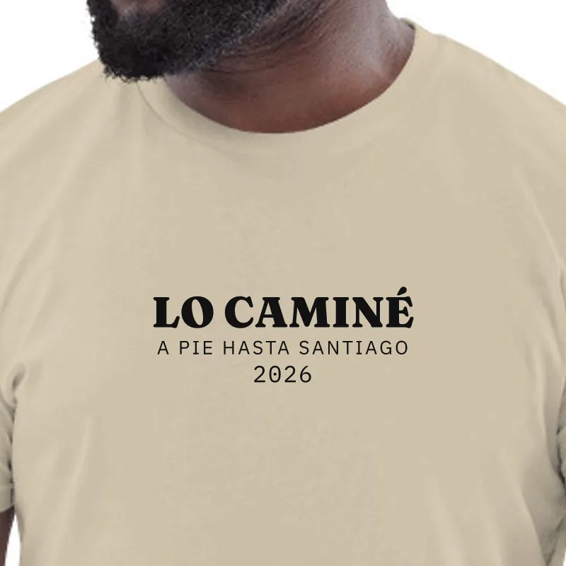 Home amb samarreta color sorra, enquadrament al segell: EL VAIG FER · A PEU FINS A SANTIAGO
