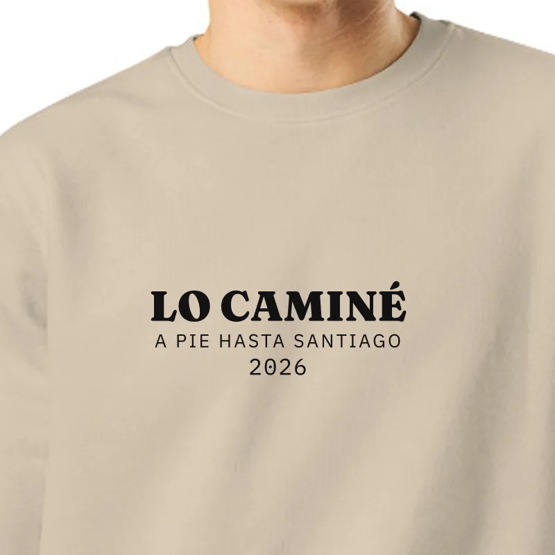 Chico con sudadera color arena, encuadre al sello: LO CAMINÉ · A PIE HASTA SANTIAGO