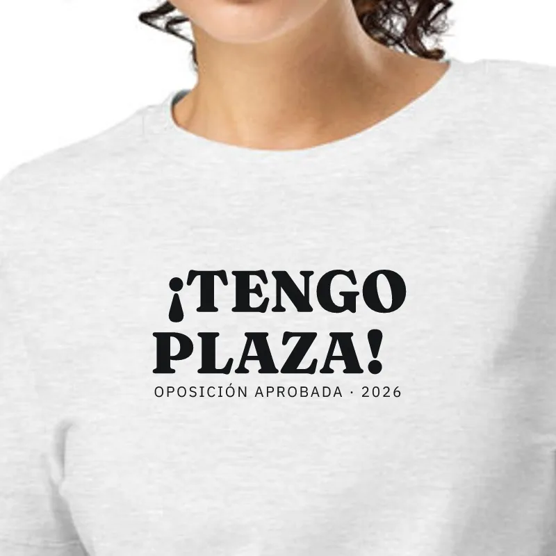 Dona amb samarreta gris jaspiat, enquadrament al segell: JA TINC PLAÇA! · OPOSICIÓ APROVADA